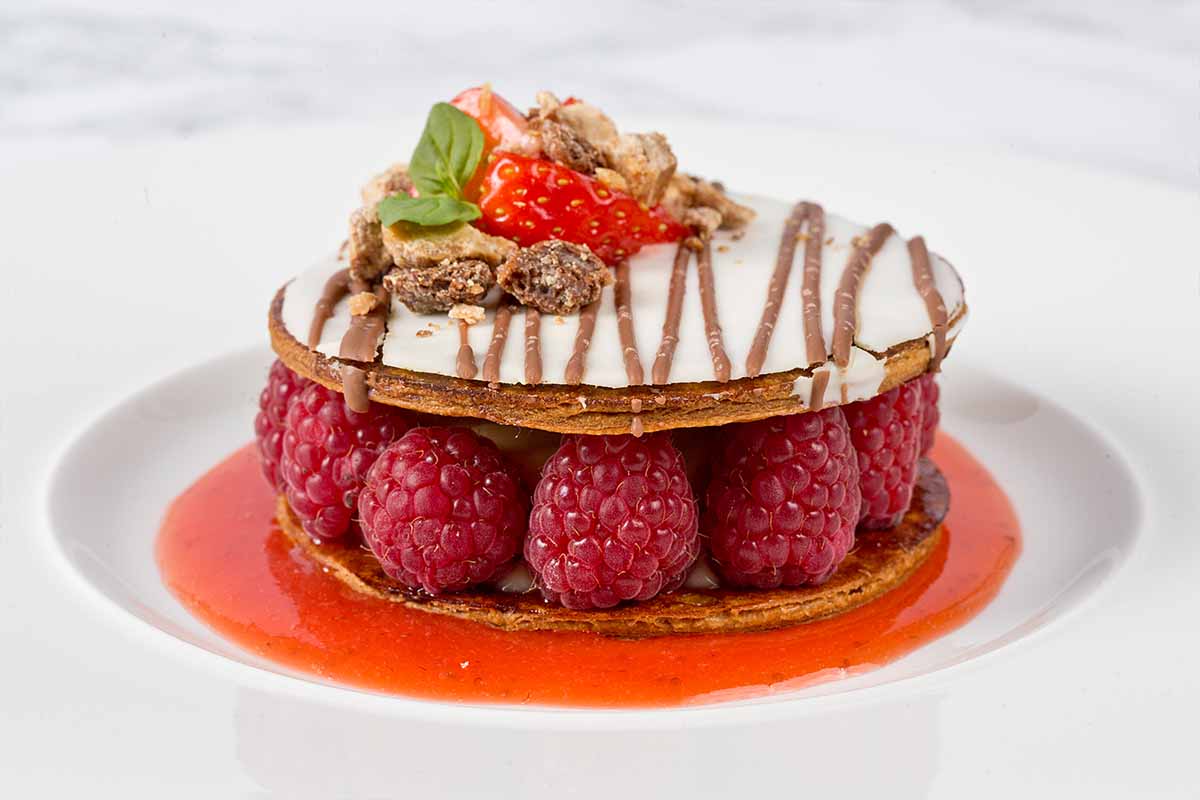 A dessert of pastry and fresh raspberries